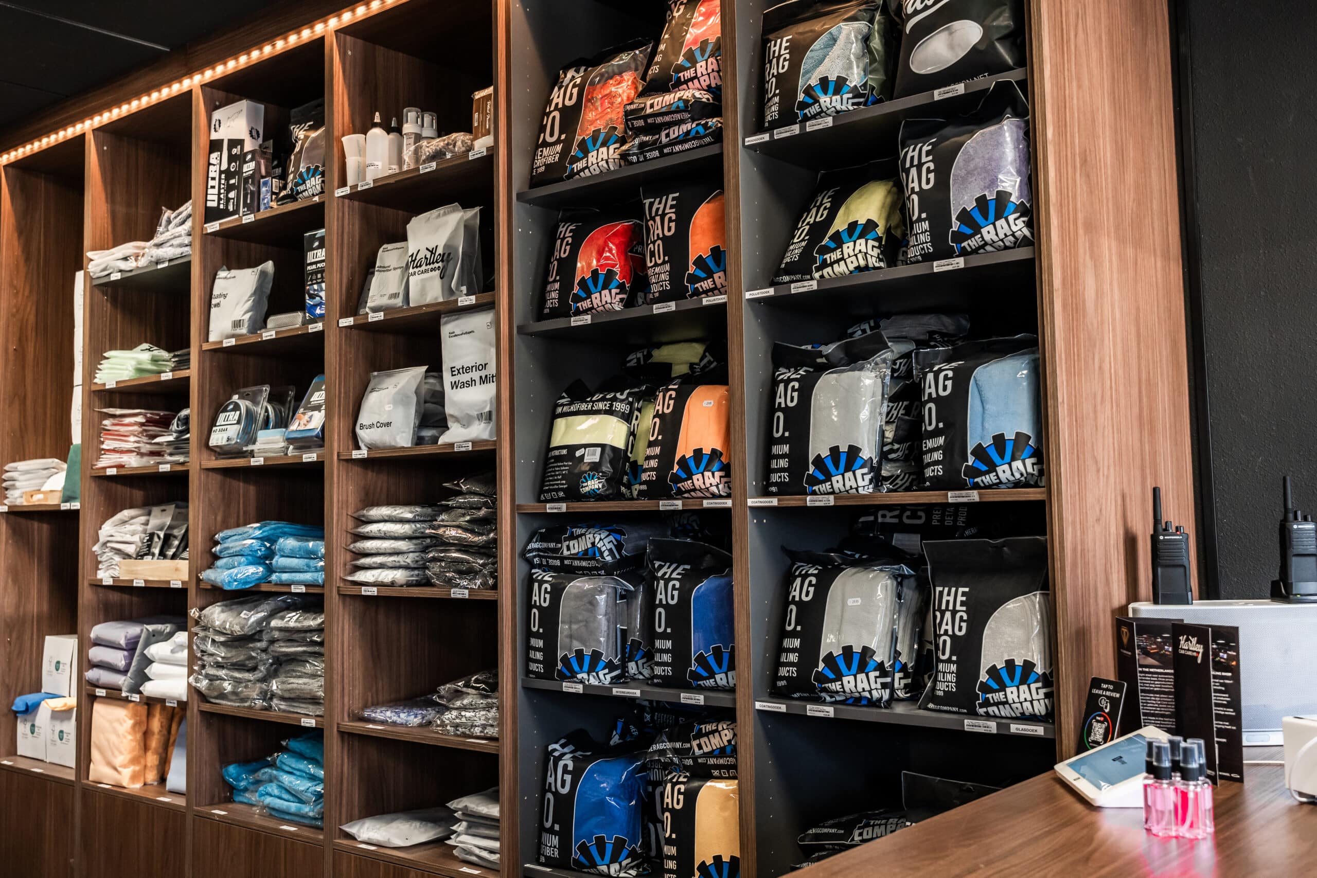 Assortiment doeken en detailingbenodigdheden in houten winkelschappen